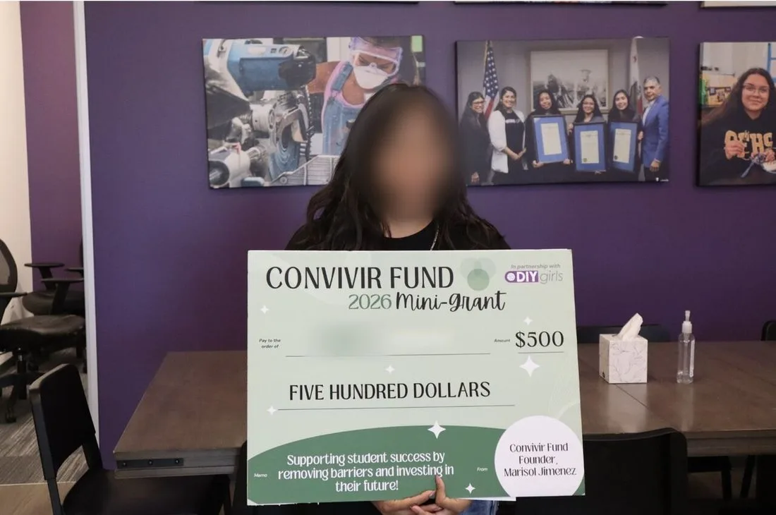 A grant recipient holding a Convivir Fund 2026 Mini-Grant check for $500.