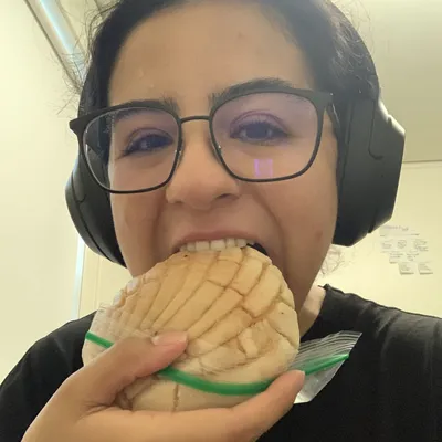 Marisol taking a big bite of a concha.