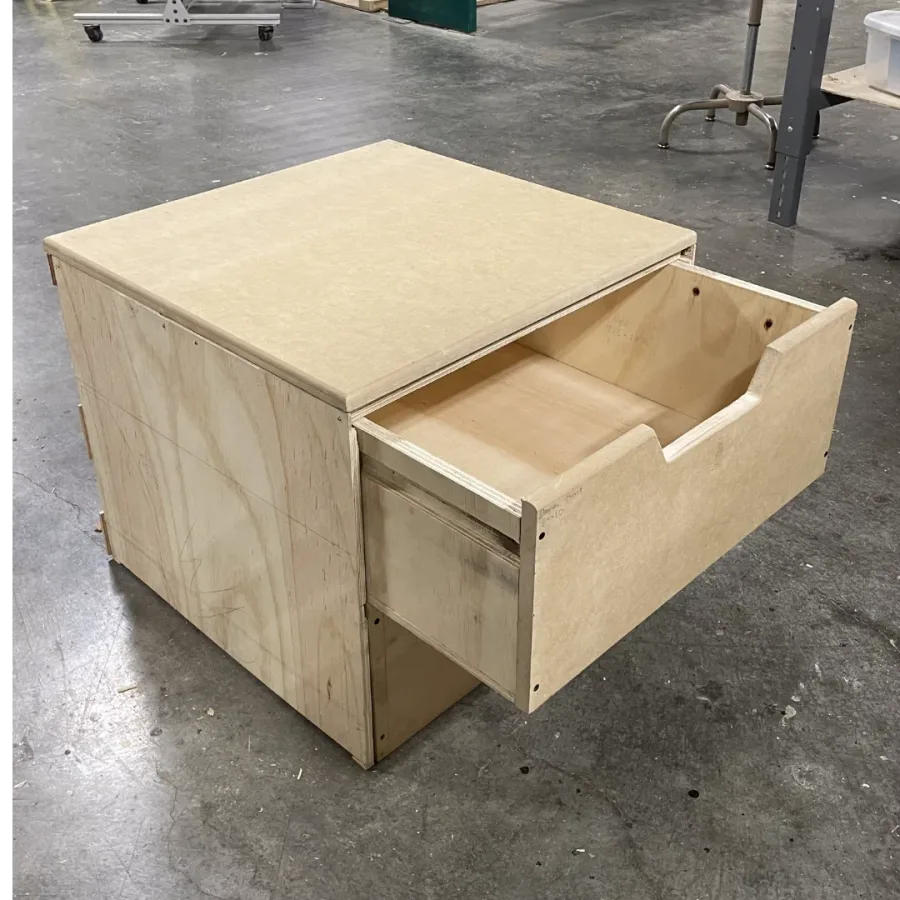 Plywood stool body with one drawer pulled open.